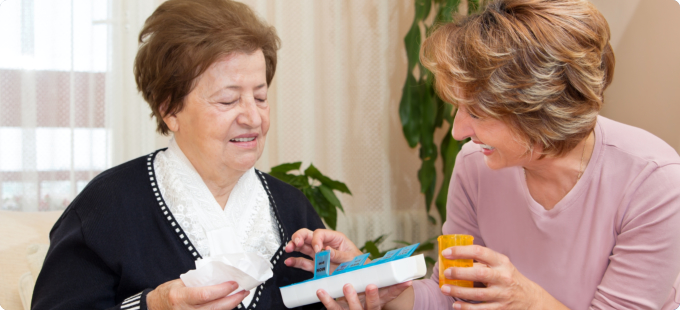 caregiver giving medicine to her patient